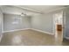 Open living room with tile flooring, ceiling fan, and doorway to the kitchen at 4101 W Leila Ave, Tampa, FL 33616