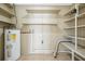 Utility room with water heater, shelving, and tile floors at 4101 W Leila Ave, Tampa, FL 33616