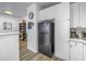 View from the dining area to the kitchen with black refrigerator and white cabinetry at 4221 W Spruce St # 1325, Tampa, FL 33607