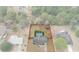 Aerial view of a property with a fenced backyard and pool, set amongst mature trees at 4553 Kirkland Ave, Spring Hill, FL 34606