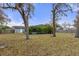The backyard features mature trees, a privacy fence, and an enclosed pool area at 4553 Kirkland Ave, Spring Hill, FL 34606