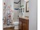 Cozy bathroom featuring floral shower curtains, tiled shower, and dark wood vanity at 4553 Kirkland Ave, Spring Hill, FL 34606