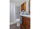 This bathroom features a white shower curtain, wood cabinets, and a coordinating sink at 4553 Kirkland Ave, Spring Hill, FL 34606