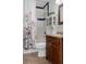 A well-lit bathroom features a floral curtain, wood vanity, and classic finishes at 4553 Kirkland Ave, Spring Hill, FL 34606