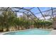 Refreshing screened-in pool surrounded by lush greenery, creating a private and serene outdoor retreat at 4553 Kirkland Ave, Spring Hill, FL 34606