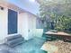 Rear entrance and patio featuring a small raised deck, concrete steps, and two exterior access doors at 4604 Courtland St, Tampa, FL 33610