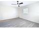 Minimalist bedroom featuring light grey wood-look flooring, neutral walls, a ceiling fan and a bright window at 4604 Courtland St, Tampa, FL 33610