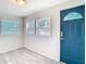Welcoming entryway with light grey wood-look flooring, and two windows near a bright blue front door at 4604 Courtland St, Tampa, FL 33610
