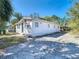 Exterior view of a bright home with a long driveway, front entry door and well-maintained landscaping at 4604 Courtland St, Tampa, FL 33610
