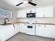 Well-lit kitchen with white cabinets and a modern microwave providing an efficient and visually appealing cooking area at 4604 Courtland St, Tampa, FL 33610