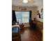 This bedroom has dark wood floors, a large window, and a desk with a gaming chair at 4915 Pond Ridge Dr, Riverview, FL 33578