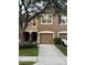 Townhouse showcasing a two-car garage, neutral-colored facade, and well-manicured landscaping at 4915 Pond Ridge Dr, Riverview, FL 33578