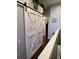 This hallway has hardwood floors, white trim, and a decorative sliding barn door at 4915 Pond Ridge Dr, Riverview, FL 33578
