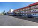 A multi-story building with red accents and parking, featuring well-maintained landscaping at 5840 30Th S Ave # 208, Gulfport, FL 33707