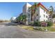 The exterior is beautifully landscaped with palm trees and shrubs near the parking area at 5840 30Th S Ave # 208, Gulfport, FL 33707