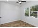 Bright bedroom with wood floors, ceiling fan, and natural light from a large window at 5891 64Th N St, St Petersburg, FL 33713