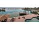 The backyard with a covered eating area, dock, chairs and tables on the patio, and an in-ground pool at 7013 Boca Ciega Dr, St Pete Beach, FL 33706