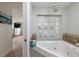 Bathroom with large soaking tub and decorative chandelier lighting at 7013 Boca Ciega Dr, St Pete Beach, FL 33706