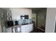 Well lit kitchen with white cabinets, stainless steel appliances, and light granite counters at 7013 Boca Ciega Dr, St Pete Beach, FL 33706