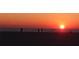 Beach sunset on the ocean with people silhouetted in the distance enjoying the view at 7013 Boca Ciega Dr, St Pete Beach, FL 33706