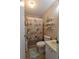 Functional bathroom featuring shower with seashell-themed decor and seashell themed shelving at 7129 El Rancho Way, Zephyrhills, FL 33541