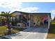 Inviting home featuring carport, palm tree, stylish furniture, and blue accents, creating a cozy curb appeal at 7129 El Rancho Way, Zephyrhills, FL 33541