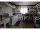 Functional laundry room with a washing machine, utility sink, storage shelves, and linoleum flooring at 7129 El Rancho Way, Zephyrhills, FL 33541