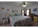 Inviting bedroom with ceiling fan, beach themed decor, and large bed at 7129 El Rancho Way, Zephyrhills, FL 33541