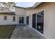 Exterior of home with a concrete patio and sliding glass doors at 8359 Wrens Way Pass, Largo, FL 33773