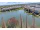 Aerial view of a tranquil lake surrounded by residential homes and lush green trees at 8835 Moonlit Meadows Loop, Riverview, FL 33578