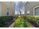 A view between two buildings leads to the lake, featuring a grassy backyard and mature trees at 8835 Moonlit Meadows Loop, Riverview, FL 33578