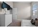 Comfortable bedroom with a dresser, TV, and a window offering natural light at 8835 Moonlit Meadows Loop, Riverview, FL 33578