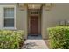 Charming front door with a 'hello' door mat surrounded by well-maintained bushes at 8835 Moonlit Meadows Loop, Riverview, FL 33578
