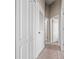 Well-lit hallway featuring multiple doors and neutral carpeting at 8835 Moonlit Meadows Loop, Riverview, FL 33578