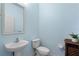 Stylish powder room with a sleek sink, toilet, and decorative cabinet at 8835 Moonlit Meadows Loop, Riverview, FL 33578