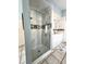 Modern bathroom featuring a glass-enclosed shower with decorative tile and double sinks at 10251 Oasis Palm Dr, Tampa, FL 33615