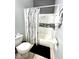 Cozy bathroom with a tub featuring white marble-like tile, grey mosaic stripe and black and white tree patterned shower curtain at 10251 Oasis Palm Dr, Tampa, FL 33615