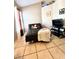 Cozy bedroom with tile floors, a black futon covered with a cream-colored blanket, and a TV with a black stand at 10251 Oasis Palm Dr, Tampa, FL 33615