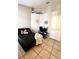 Bedroom with a black futon, tile floors, a TV, and a white paneled door with a silver knob at 10251 Oasis Palm Dr, Tampa, FL 33615