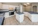 Kitchen featuring white cabinets, stainless steel appliances, an eat-in island, and tile flooring at 10251 Oasis Palm Dr, Tampa, FL 33615