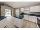 Kitchen featuring white cabinets, stainless steel appliances, an island, and sliding glass doors that lead to the pool at 10251 Oasis Palm Dr, Tampa, FL 33615