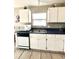 Kitchen featuring white cabinets, a black dishwasher, white microwave and light color tile flooring at 10251 Oasis Palm Dr, Tampa, FL 33615