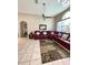 Living room featuring tiled floors, ceiling fan, and cozy red sectional at 10251 Oasis Palm Dr, Tampa, FL 33615