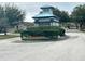 Neighborhood entrance with landscaped roundabout and charming architecture at 10251 Oasis Palm Dr, Tampa, FL 33615