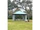 Covered park pavilion with picnic tables, a bench, and trash cans, perfect for outdoor dining and relaxation at 10251 Oasis Palm Dr, Tampa, FL 33615