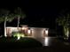 Inviting home exterior at night with a manicured lawn and illuminated by landscape lighting at 11044 Jenkins Ct, San Antonio, FL 33576