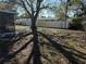 Fenced in backyard with a shade tree casting shadows on the lawn and a view of a screened in patio at 11470 88Th Ter, Seminole, FL 33772