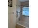 Neutral-toned bathroom featuring tiled walls and a shower-tub combination with safety bars at 11470 88Th Ter, Seminole, FL 33772