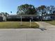 Quaint single-story home with manicured hedges, a white mailbox and a concrete driveway to the attached garage at 11470 88Th Ter, Seminole, FL 33772