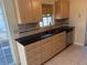 Well-lit kitchen with tan cabinets, black granite countertops, and stainless steel appliances at 11470 88Th Ter, Seminole, FL 33772
